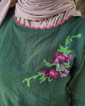 Load image into Gallery viewer, Green garment with floral embroidery, needlework neckline and a beige headscarf.