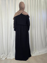 Load image into Gallery viewer, Woman wearing a black maxi dress and beige headscarf in front of a white curtain