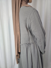 Load image into Gallery viewer, Side close up of woman wearing a gray dress with a beige hijab against a white background