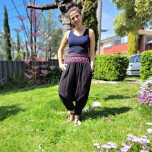 Load image into Gallery viewer, Tribal-harem-pants-in-black-with-ethnic-embroidery-on-front-waist-panel-near-tree-trunk