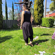 Load image into Gallery viewer, Tribal-harem-pants-in-black-with-ethnic-embroidery-on-front-waist-panel-near-tree-trunk-back-view
