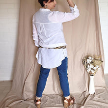 Load image into Gallery viewer, button-front-band-collar-tunic-shirt-with-button-tab-long-sleeves-mid-length-curved-hem-in-white-worn-with-jean-leggings-back-view