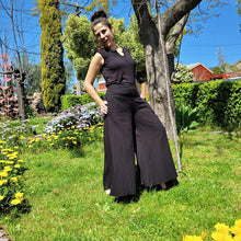 Load image into Gallery viewer, cotton-palazzo-pants-with-extra-wide-leg-fitted-mid-waist-elasticated-at-back-and-side-pockets-in-black-front-of-tree-side-view-2