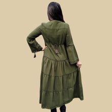 Load image into Gallery viewer, brushed-cotton-flannel-tiered-maxi-dress-in-khaki-showing-bell-sleeves-with-tassel-ties-lace-trim-on-sleeves-and-skirt-hem-and-string-tie-waist-on-dress-back