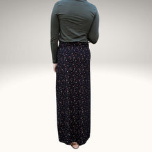 Load image into Gallery viewer, back-view-of-high-waisted-brushed-cotton-flannel-maxi-skirt-in-black-with-ditsy-floral-print-accent-pocket-on-front-right-in-solid-black-and-button-through-off-centre-front-slit