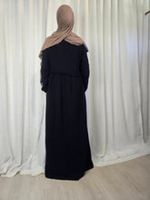 Load image into Gallery viewer, Woman wearing a black maxi dress and beige headscarf in front of a white curtain
