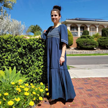 Load image into Gallery viewer, manolya-shirred-maxi-dress-with-bell-sleeves-square-neckline-empire-waist-skirt-with-ruffled-hem-in-teal-outdoor-front-view-image-next-to-hedge
