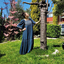 Load image into Gallery viewer, manolya-shirred-maxi-dress-with-bell-sleeves-square-neckline-empire-waist-skirt-with-ruffled-hem-in-teal-outdoor-front-view-image-next-to-tree-trunk
