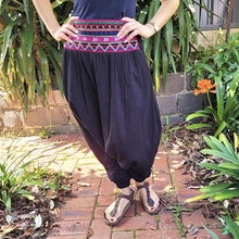 Load image into Gallery viewer, Tribal-harem-pants-in-black-with-ethnic-embroidery-on-front-waist-panel-front-of-palm-close-up
